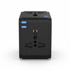Universal travel adapter plugged into a wall outlet with a USB cable charging a smartphone.